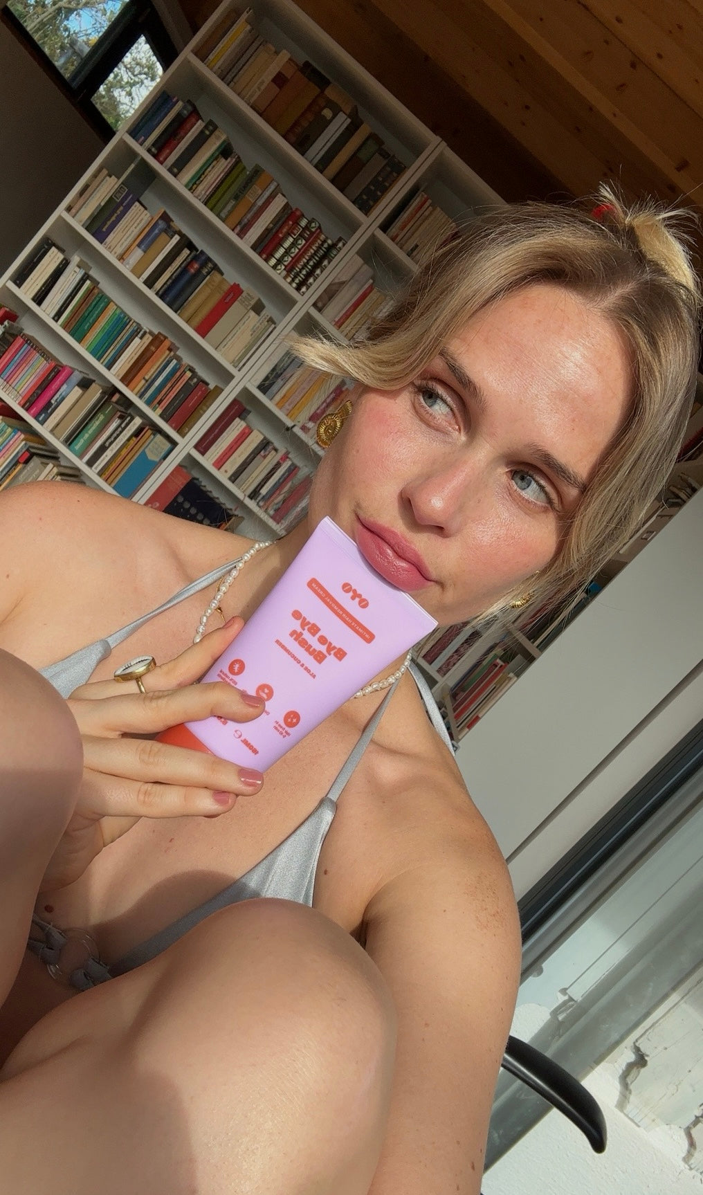 Woman holds natural skincare product near her face, promoting effective routines for healthy, nourished skin.