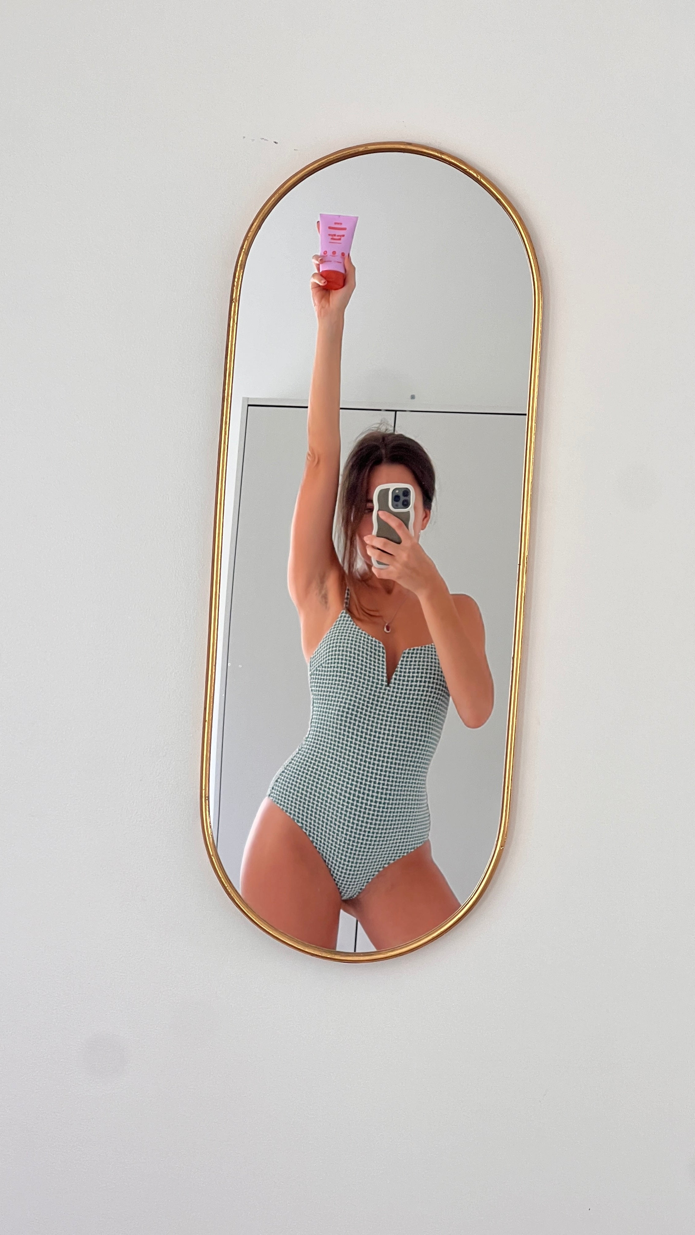 Woman in swimsuit holding natural skincare products, showcasing effective routines for intimate areas and skin care.