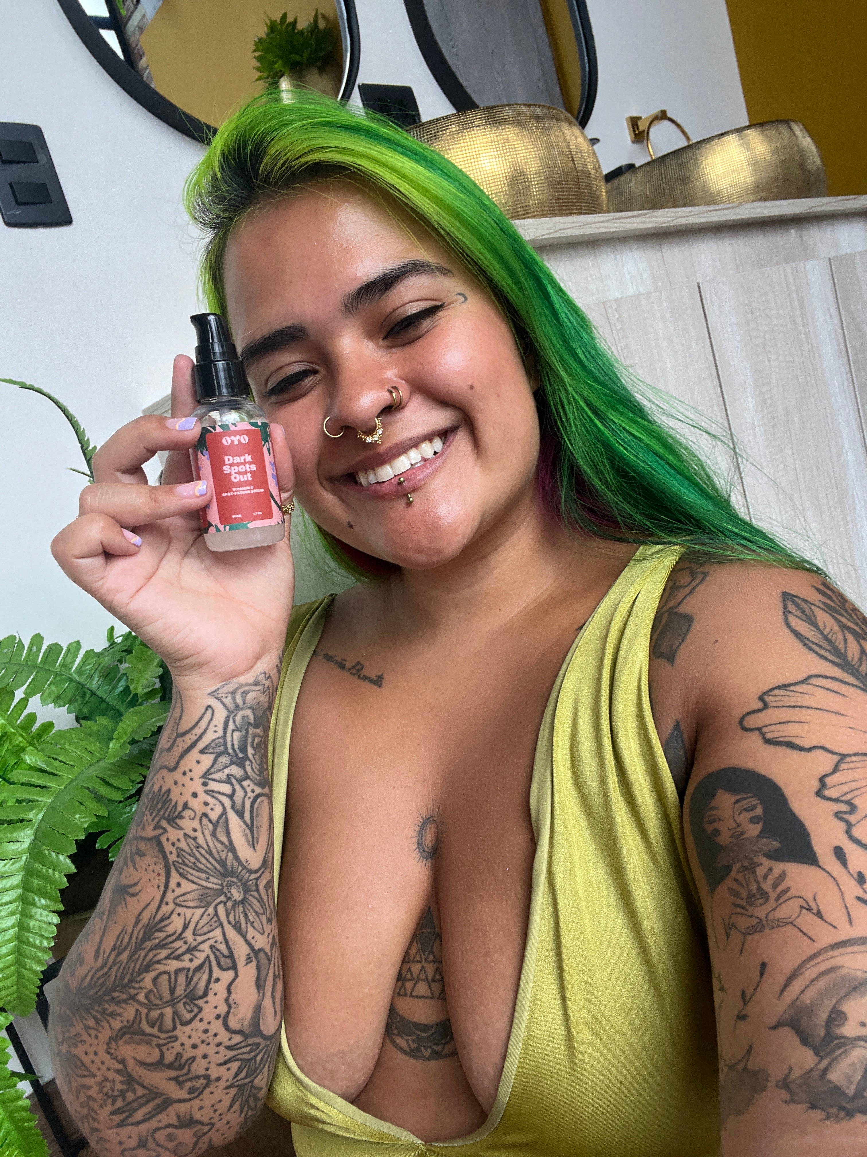 Smiling woman with green hair holding natural skincare product, promoting effective skincare for all skin types.
