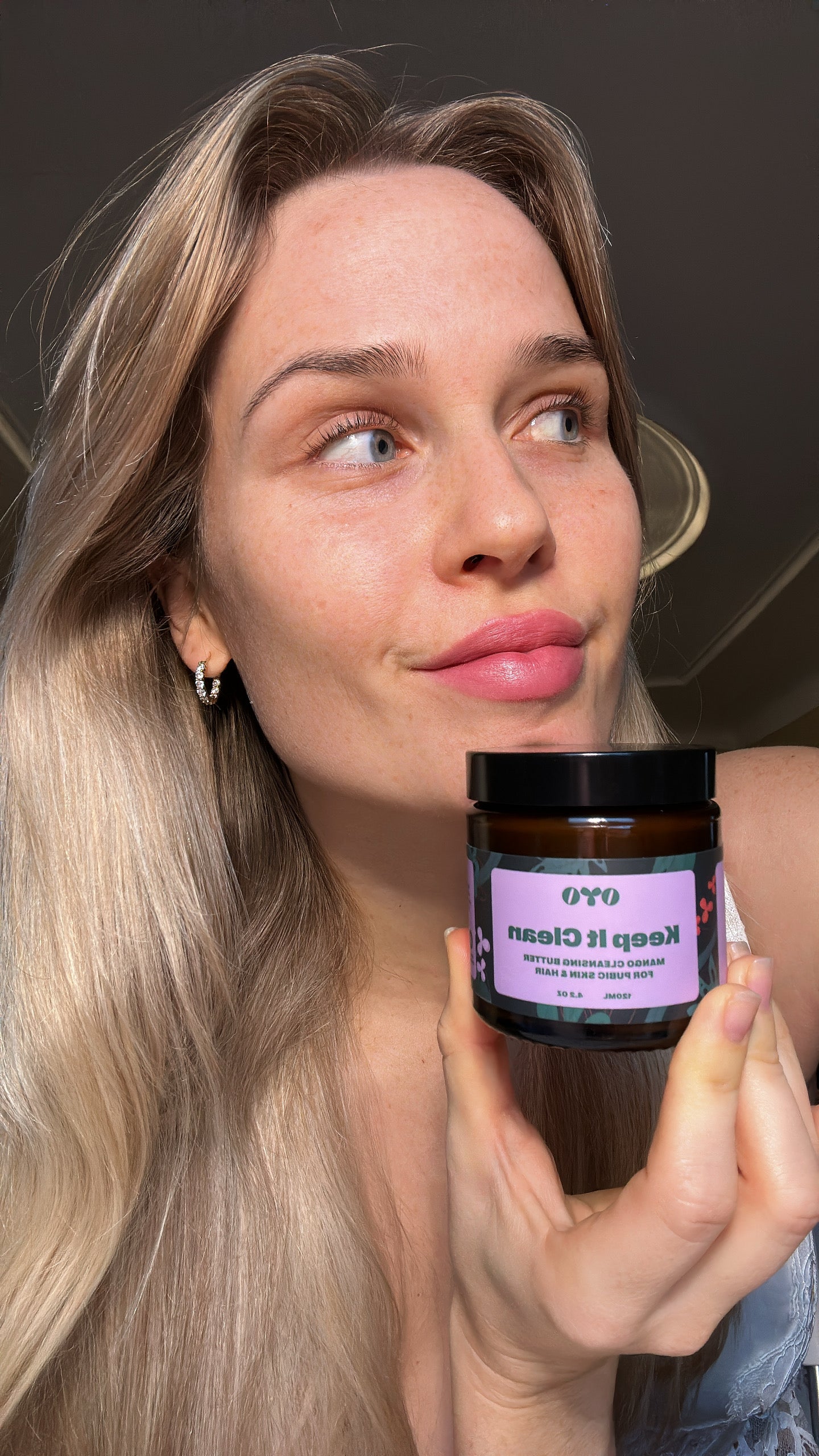 Woman holding a natural skincare product, showcasing effective skincare for intimate areas, trusted by 100k+ women.