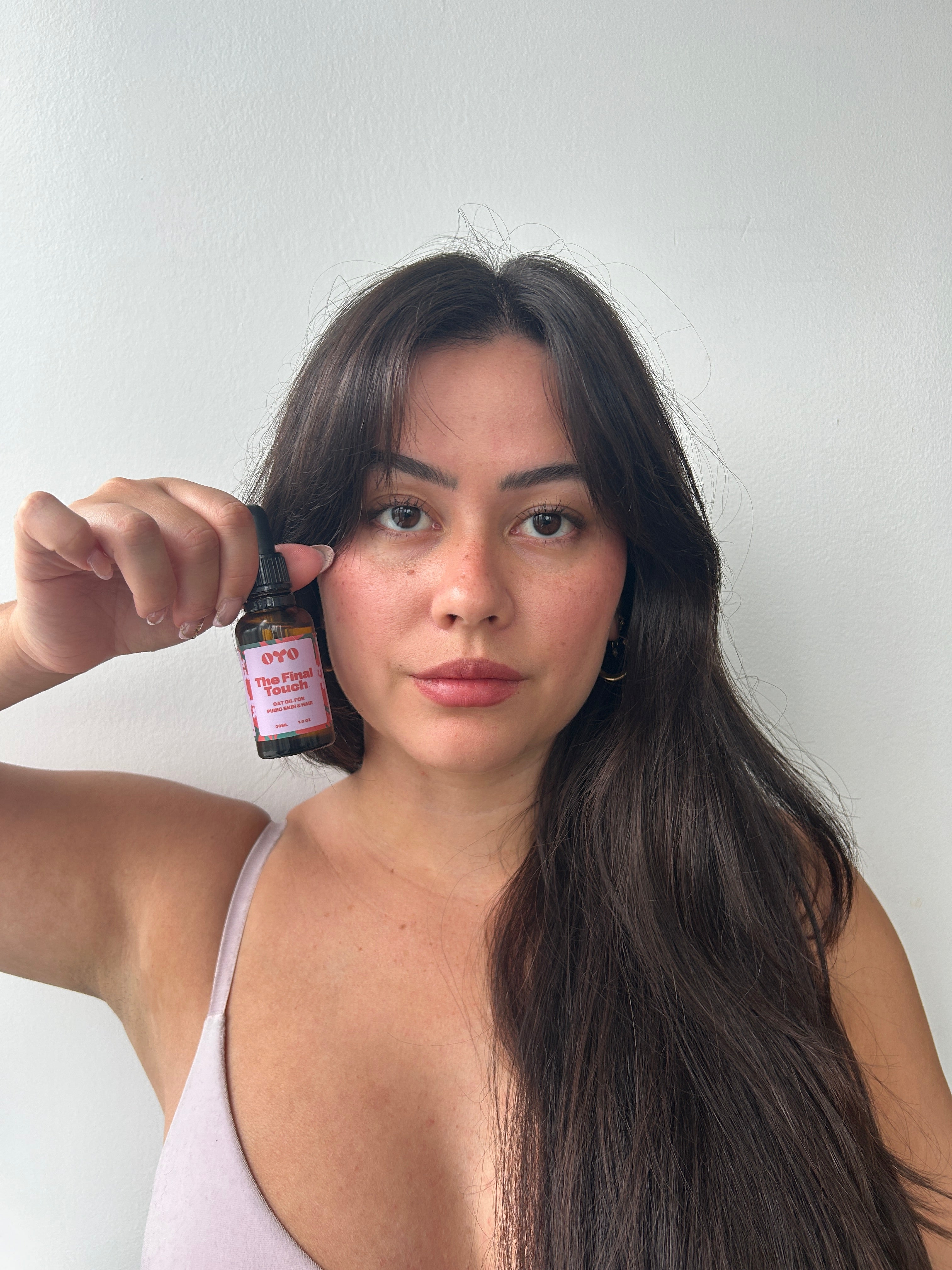 Woman holding a natural skincare product, perfect for soothing irritation and brightening problem areas.