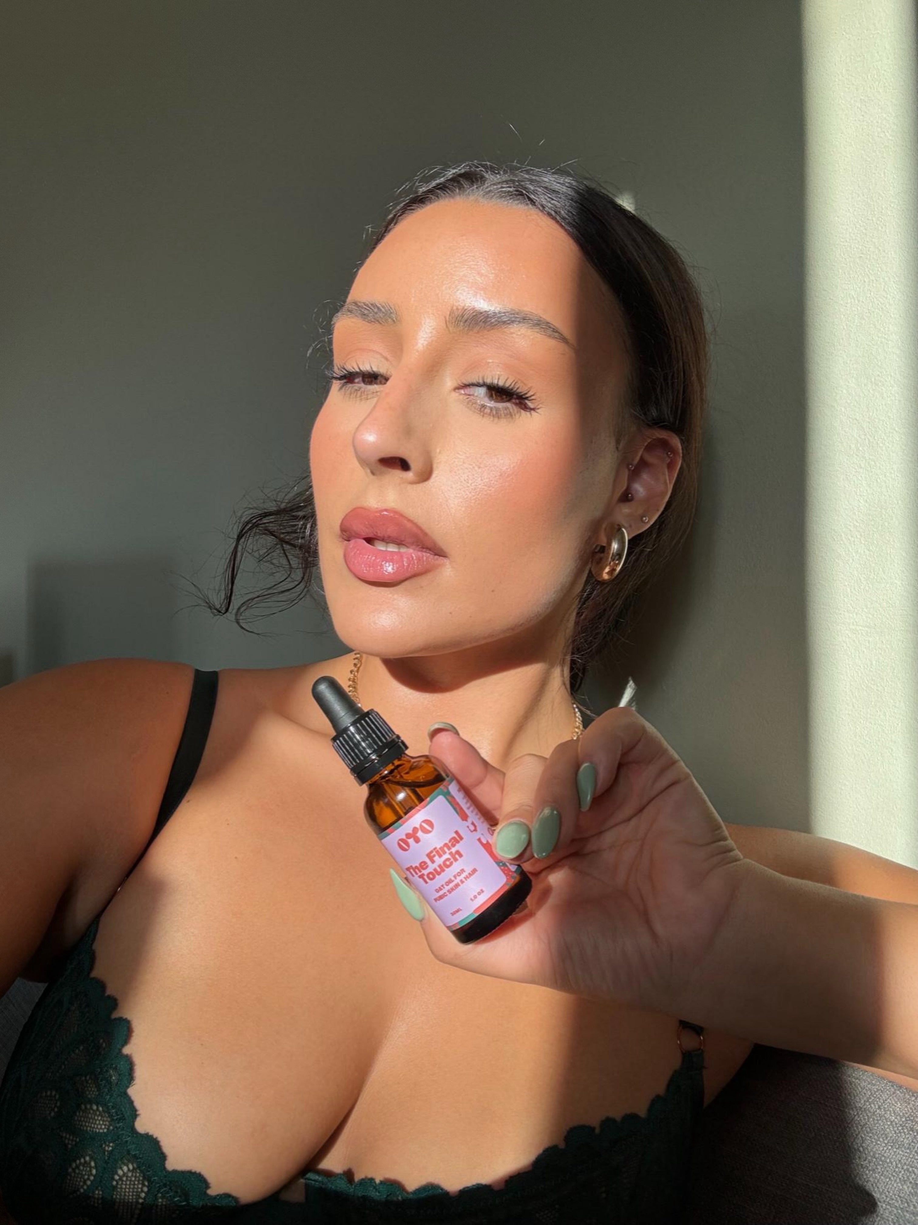 A woman holding a natural skincare oil, showcasing effective skincare for sensitive areas with clean ingredients.